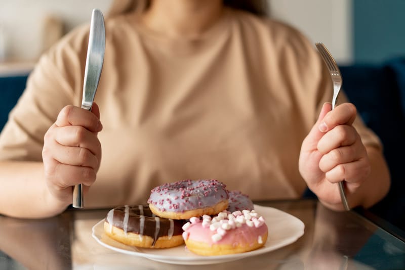 A wife is emotionally eating donuts after a disagreement with her spouse